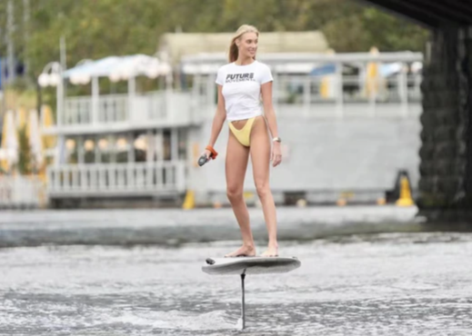 a hot girl is riding an eletric hydrofoil board